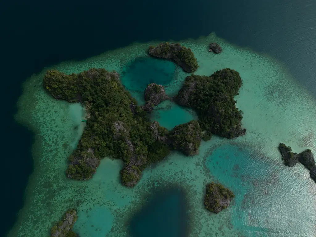 Low limestone islets scattered through turquoise shallows, with darker channels running between them